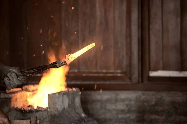 Schmied schmiedet das geschmolzene Metall mit einem Hammer, um Keris herzustellen — Stockfoto