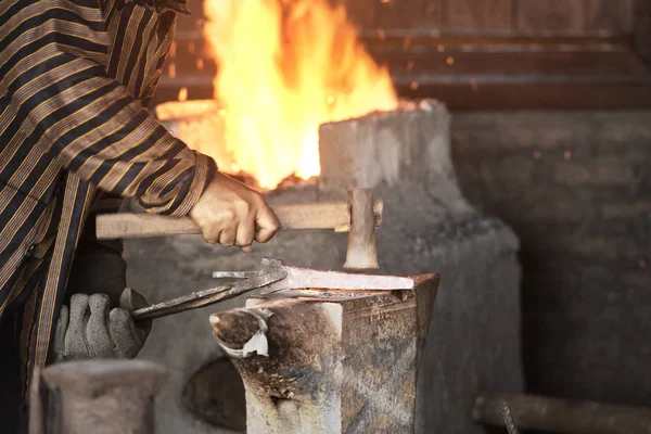 Schmied schmiedet das geschmolzene Metall mit einem Hammer, um Keris herzustellen — Stockfoto