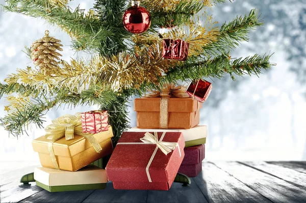 Vánoční stromek s dárkovou krabicí na dřevěné podlaze — Stock fotografie