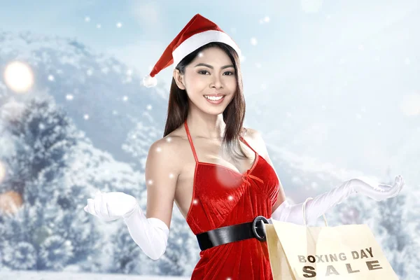Asiatische Frau im Weihnachtsmann-Kostüm mit Einkaufstaschen mit Boxen — Stockfoto