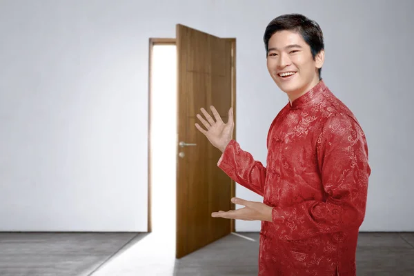 Un homme chinois asiatique en robe cheongsam invite dans la maison t — Photo