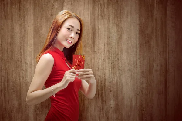 Asiatico cinese donna in un cheongsam vestito tenendo rosso buste — Foto Stock