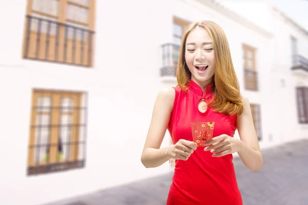 Ázsiai kínai nő egy cheongsam ruha kezében piros borítékok — Stock Fotó