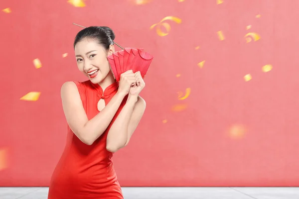 Asiatisk kinesisk kvinna i en cheongsam klänning med röda kuvert — Stockfoto