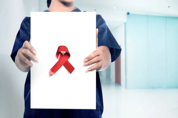 Woman doctor showing a red ribbon — Stock Photo, Image