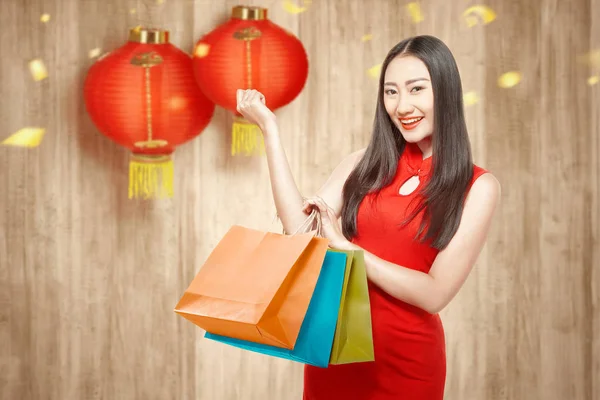 Asiática china mujer en cheongsam vestido sosteniendo bolsas de compras —  Fotos de Stock