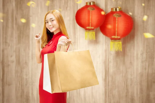Asiática china mujer en cheongsam vestido sosteniendo bolsas de compras — Foto de Stock