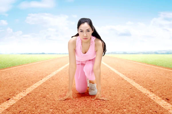 Asiática mulher corredor pronto para correr na pista de corrida — Fotografia de Stock