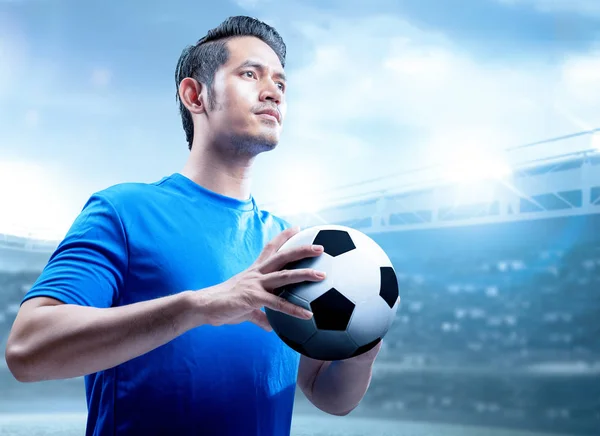 Asiatisk fotbollsspelare man som håller bollen på fotbollsplanen — Stockfoto