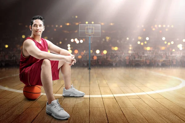 Asiático hombre baloncesto jugador sentado en la pelota — Foto de Stock