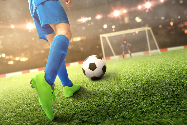 Задний вид футболиста, пинающего мяч по мячу
