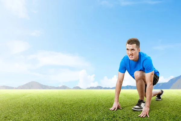 Asiatischer Läufer bereit für den Lauf auf dem Rasenplatz — Stockfoto