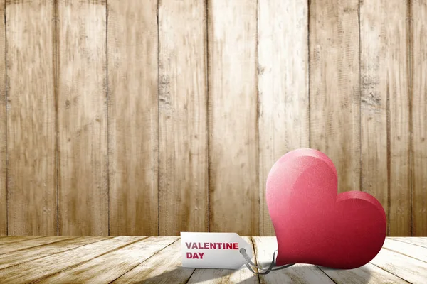 Corazón rojo en la mesa de madera con texto del día de San Valentín en la etiqueta l — Foto de Stock