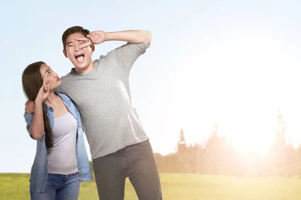 Asian couple standing with a funny facial expression — Stock Photo, Image