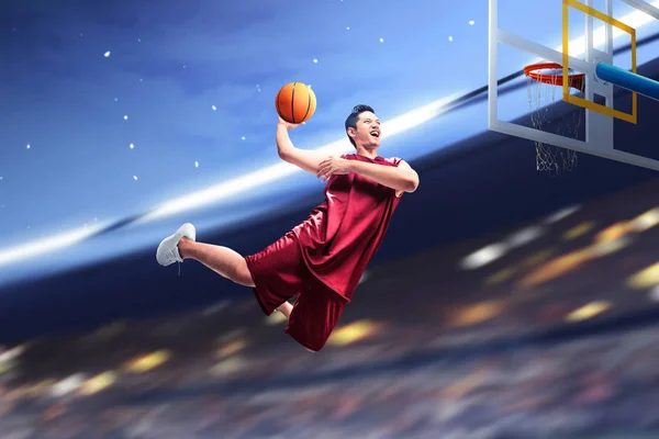 Ασιάτης μπασκετμπολίστας πηδάει στον αέρα με την μπάλα να προσπαθεί — Φωτογραφία Αρχείου