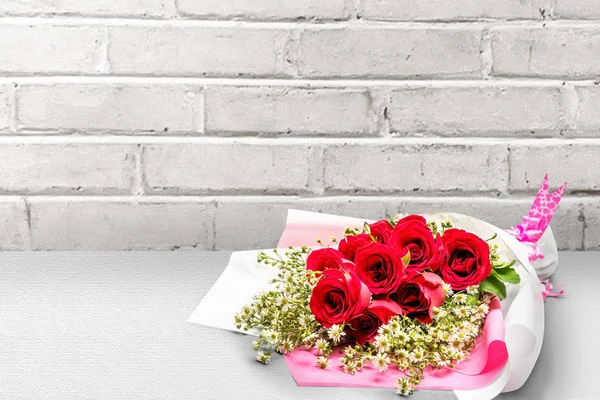Rode rozen boeket verpakt in papier met een roze lint op de flo — Stockfoto