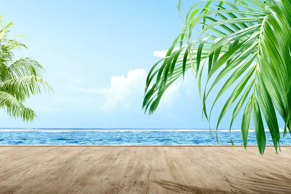 Houten vloer met zeezicht en groen palmblad — Stockfoto
