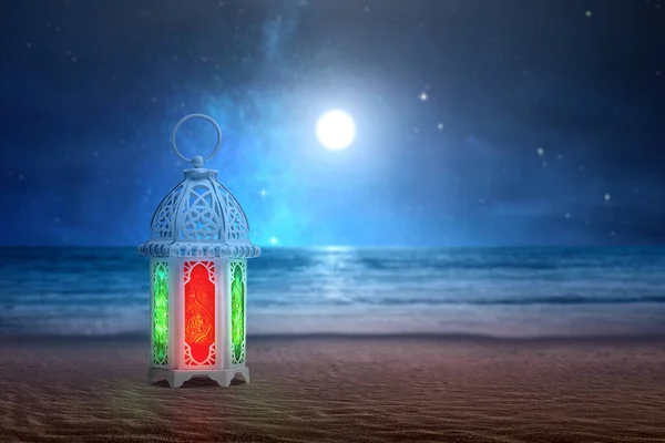 Arabic lamp with colorful light on the sandy beach with the night scene background