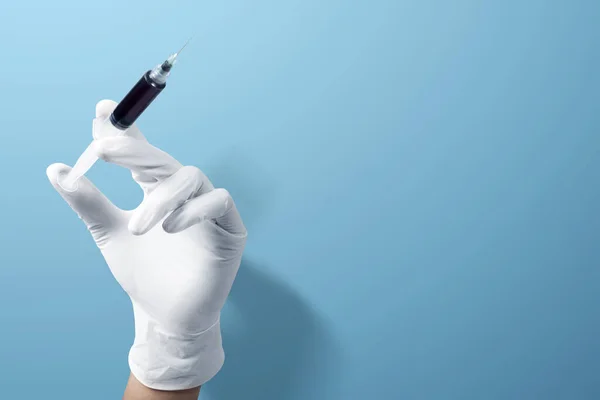 Arzt Schutzhandschuhen Hält Spritze Mit Blauem Hintergrund — Stockfoto