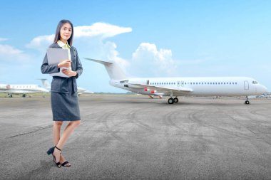 Asyalı iş kadını dışarıda dizüstü bilgisayar taşırken