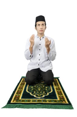 Asyalı Müslüman adam beyaz arka planda el ele tutuşup dua ediyor.