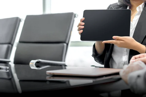 Businesswoman with a tablet discussing business on the workplace