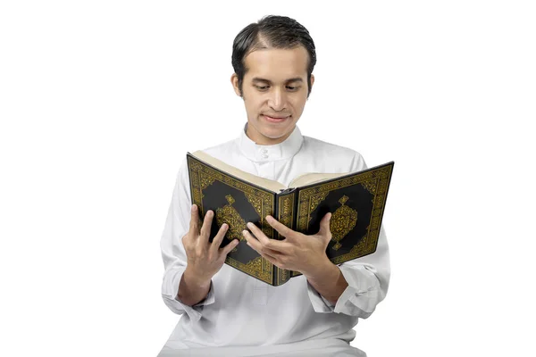 在白人背景下阅读 古兰经 的亚裔穆斯林男子 — 图库照片