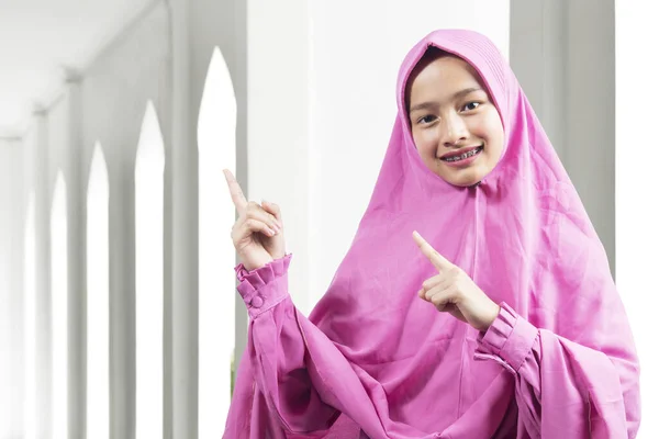 披着面纱的亚洲穆斯林妇女指着清真寺里面的什么东西 供复制空间的空区域 — 图库照片