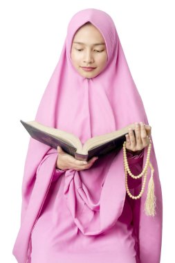 Duvaklı Asyalı Müslüman kadın elinde dua boncuklarıyla ve beyaz arka planda izole bir şekilde Kur 'an okuyarak