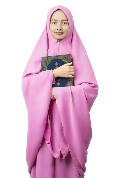 ベールに身を包んだアジア系ムスリム女性は 白い背景の上にクルアーンを隔離し — ストック写真
