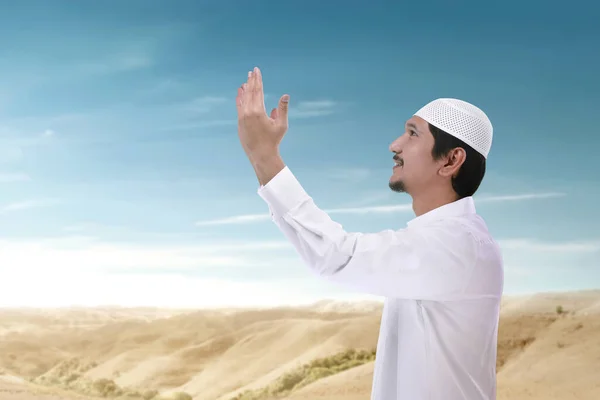 アジア系ムスリムの男性が立ち上がり 青空を背景に手を挙げて祈る — ストック写真
