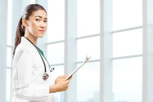 Asian doctor woman with stethoscope holding a clipboard in the hospital