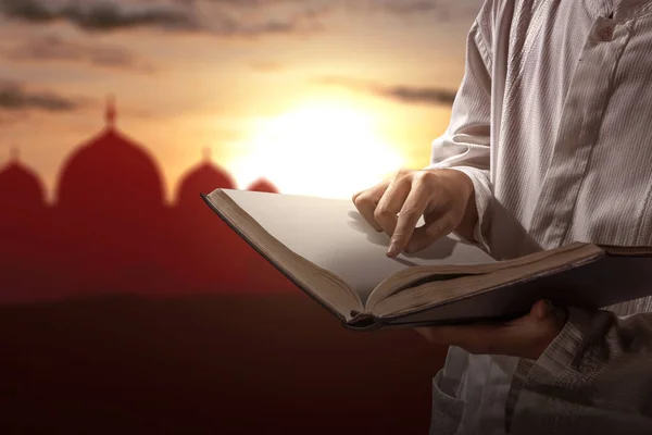 Hombre Musulmán Leyendo Corán Sus Manos Con Fondo Cielo Atardecer — Foto de Stock