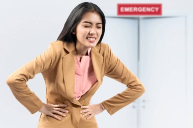 Asyalı iş kadını hastanenin acil servisinde midesi ağrıyor.