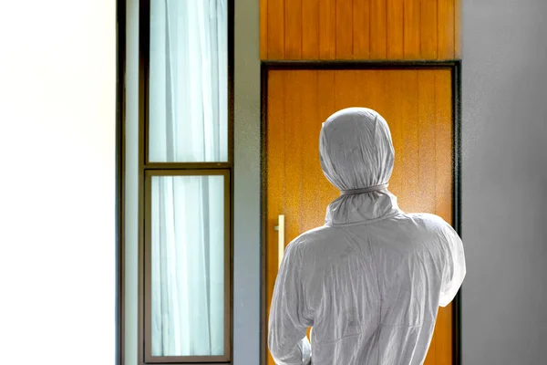 白い保護服を着た男が家に消毒剤を噴霧する 広がるインフルエンザの病気を防ぐ コロナウイルス — ストック写真