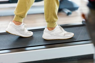 Spor salonunda koşu bandında egzersiz yapan bir adam.