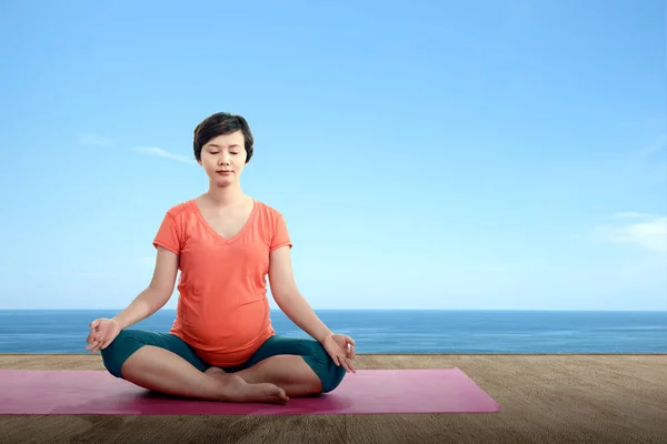 Asiatisk Gravid Kvinna Praktiserar Yoga Yogamatta Med Havsutsikt Bakgrund — Stockfoto