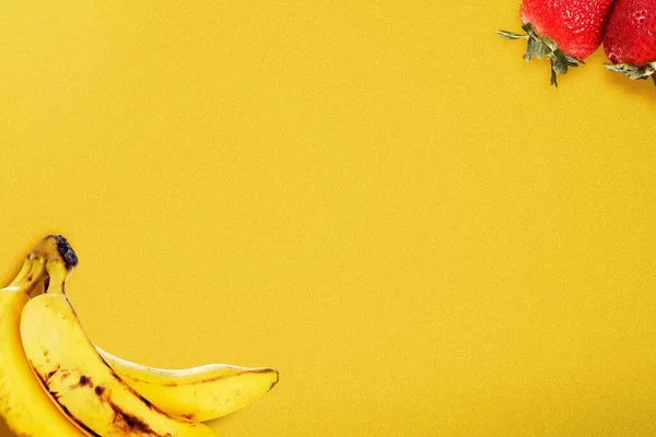 Banane Und Erdbeere Auf Leuchtend Gelbem Hintergrund — Stockfoto