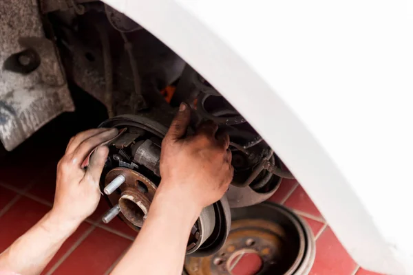 Car mechanic repairing car disk brake on the garage