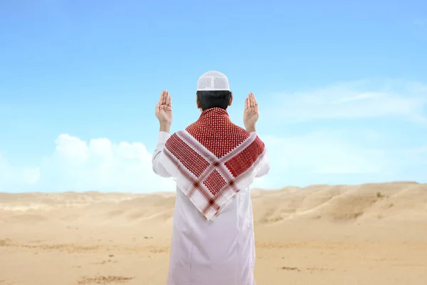 亚洲穆斯林男子高举双手站在蓝天背景下祈祷的后视镜 — 图库照片