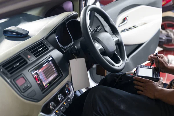 Man with diagnostic tools doing car diagnostic on the garage