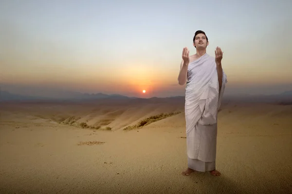 砂丘の上で腕を上げながら立ち祈りをするイスラム教徒の男性 — ストック写真