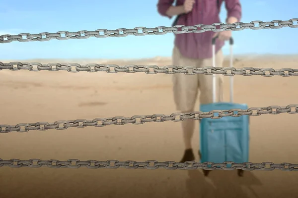 砂漠にリュックとスーツケースを持つ男とチェーンフェンス 世界難民の日のコンセプト — ストック写真