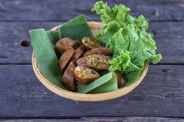 Muz yaprağı tabağında Sai Aua (Kuzey Tayland Baharatlı Sosisi)