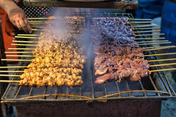 Skewered chicken and chicken liver on hot grille, thai popular street food.