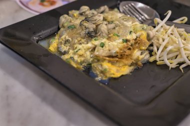 Kızarmış midye krepleri, yumurta hamurunda kızartılmış midyeler. Sahne