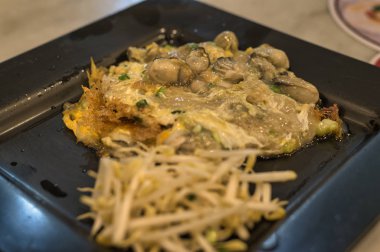 Kızarmış midye krepleri, yumurta hamurunda kızartılmış midyeler. Sahne