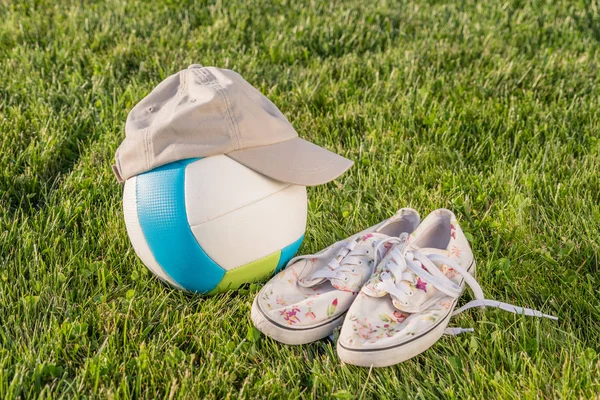 Ball, cap, shoes on the grass