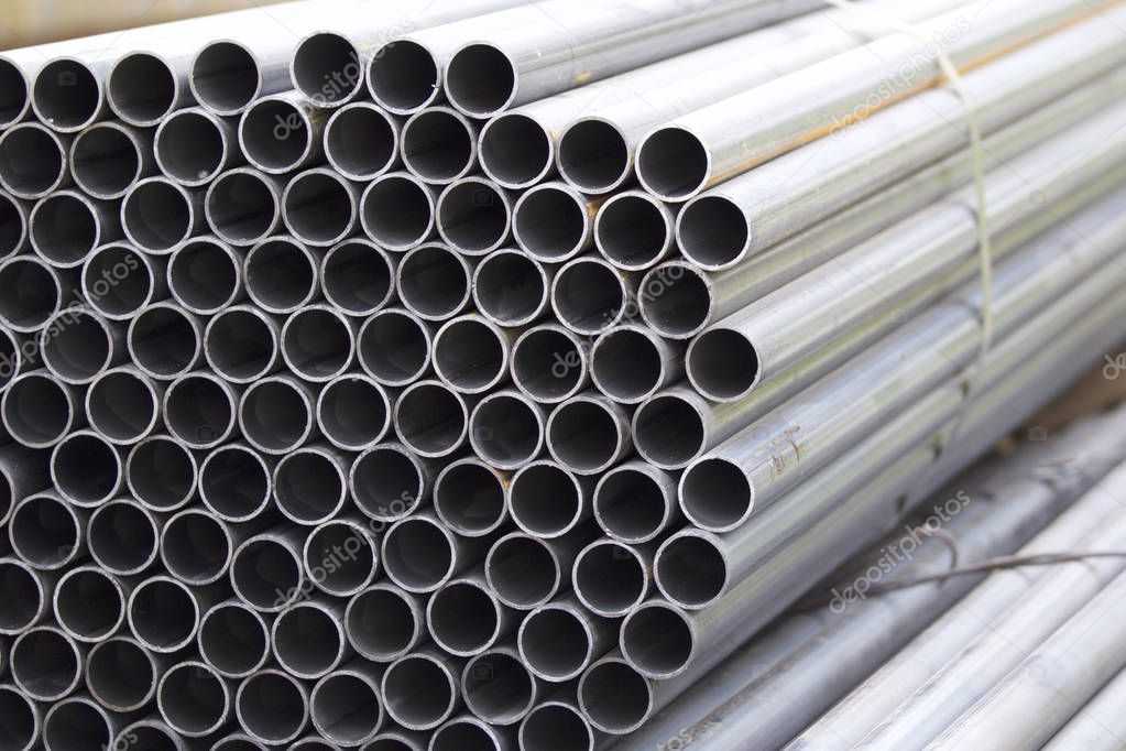 Metal profile pipe of round section in packs at the warehouse of metal products