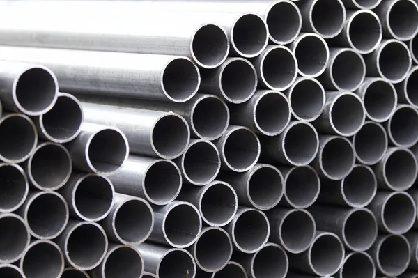 Металеві профільні труби круглого перетину в пачках на складі металевих виробів — стокове фото